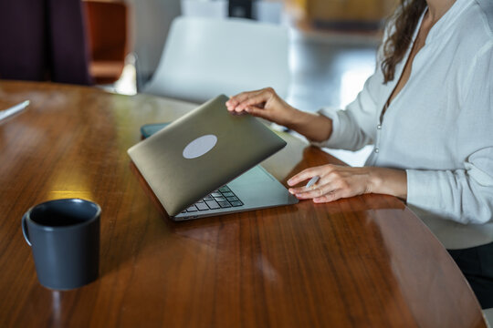 Businesswoman closing laptop finishing work for the day