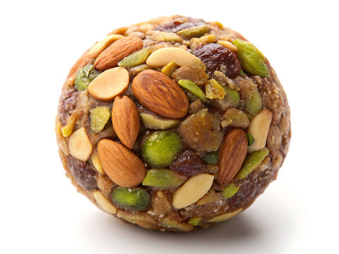 Dry Fruit Laddu, round Indian sweet packed with pistachios, almonds, dates and figs, isolated