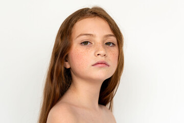 Fototapeta premium Portrait of a young white girl with long brown hair and freckles