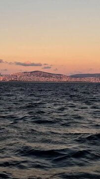 View of the city skyline at sunset over the water in a coastal area