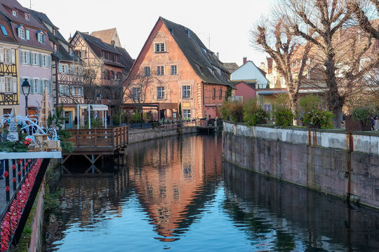 Half-timbered houses reflecting on a canal in Colmar, France.