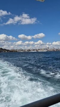 View of the city from a boat on the water on a sunny day with clouds in the sky