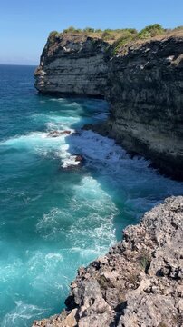 Sea waves crashing on rocky shore, high angle view.