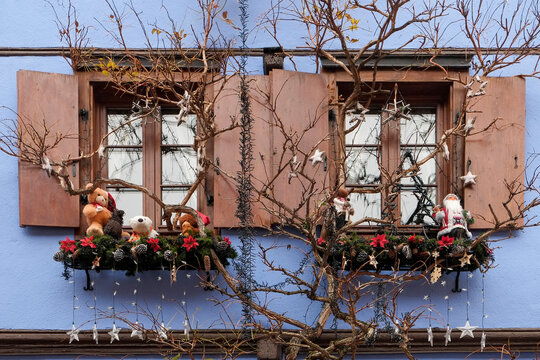 Rustic Christmas window display with bare branches and ornaments in France