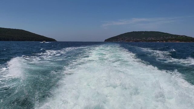 Boat ride through blue water near islands on a sunny day