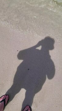 Footsteps on the sandy beach in bright sunlight near the water's edge