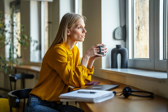 Young woman relaxing coffee break looking through window