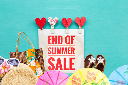 End of summer sale sign with heart clip and summer decoration items on blue background, summer season promotion background idea
