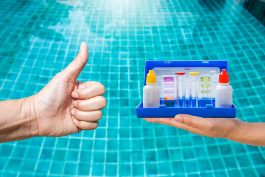 Water tester test kit on girl hand over clear swimming pool background, quality water testing test kit, pool maintenance and service business concept