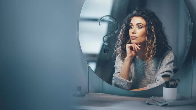 Thoughtful young woman with curly hair looking in mirror with question mark symbol reflecting self reflection and doubt