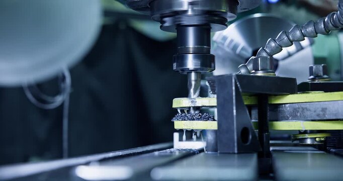 Milling cutter cutting metal workpiece on industrial workshop bench with rotating spindle, blue tinting.