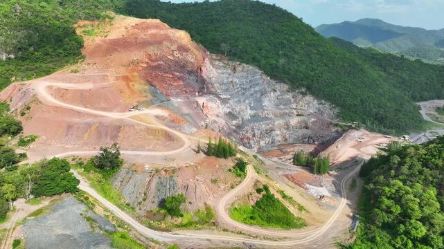 Aerial photography of mountain mining activities showing exposed geological layers, removed landscapes, and the balance between economic resource demand, conservation, and ecological recovery. 4k.
