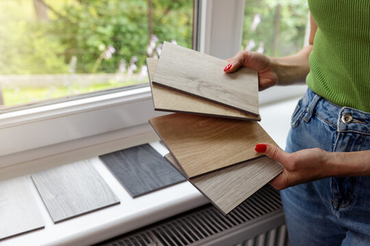 Woman choosing materials from wood samples for home flooring and furniture. Interior design and renovation