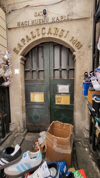 Old entrance to Kapalicarsi bazaar with footwear and boxes outside in Istanbul, Turkey