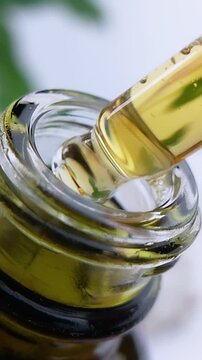 Close up of a pipette filled with honey tea yellow liquid being pumped. Beauty serum or natural extract dispensing concept.