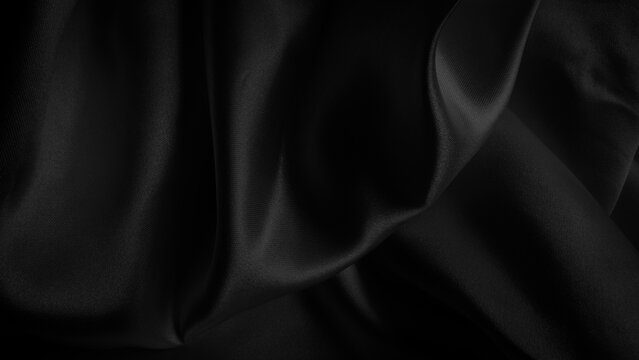 Smooth elegant black silk fabric waves background texture with luxurious silky shine and dark rich shadows. Close up of draped black satin material showing smooth folds and soft light reflections
