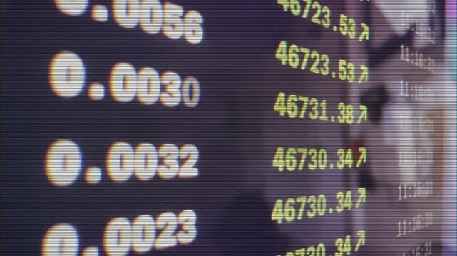 Closeup panning financial market ticker displaying changing prices and decimals.