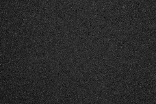 Texture of black synthetic sponge foam rubber sheet close up back
