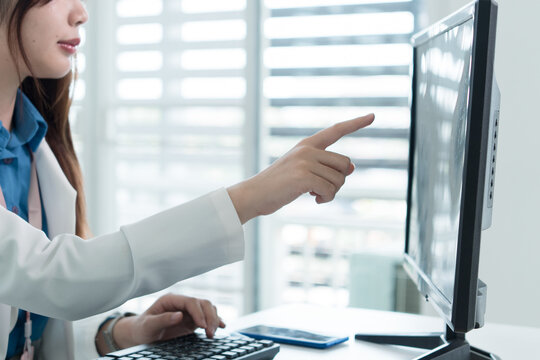 Young Businesswoman Working at Office Desk While Managing Documents and Mobile Communication.