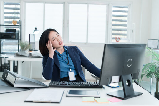 Young Businesswoman Working at Office Desk While Managing Documents and Mobile Communication.