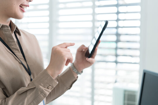 Young Businesswoman Working at Office Desk While Managing Documents and Mobile Communication.
