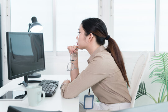 Young Businesswoman Working at Office Desk While Managing Documents and Mobile Communication.