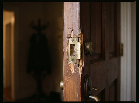 Close up of a damaged wooden front door frame after a forced break in attempt at a residential home