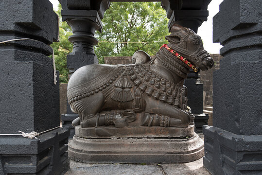 A beautifully carved Nandi (bull) idol sits in its own pavilion at the entrance of the Rameshwar Temple, Kshetra Mahuli, 18th-century Shiva shrine located at Krishna River, Satara, Maharashtra, India.
