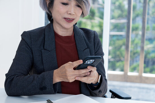 Businesswoman Texting on Smartphone at Office Desk