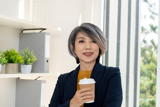 Businesswoman Enjoying Coffee Break by Office Window