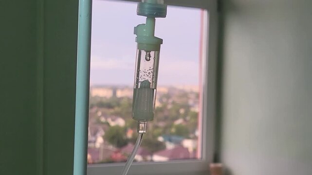 Medical infusion bottle hanging in a ward during sunset. clinical healthcare, hospital recovery, professional care.