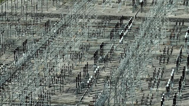 Aerial capture of high voltage electrical systems and transmission facilities, highlighting engineering complexity, grid resilience, and the backbone of national energy infrastructure. 4k.
