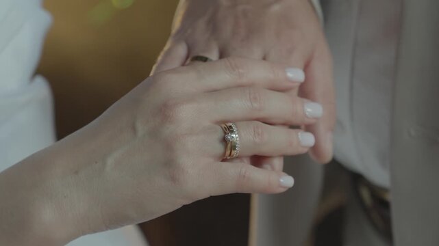 Close-up of the newlyweds' hands with a ring.