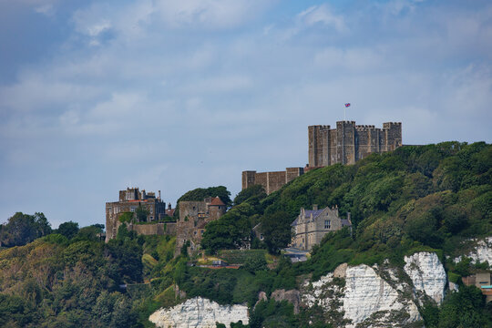 Ancient Dover castle fortress perched atop cliffs above village