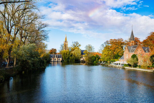 Autumn riverside scene with church spire and colorful trees