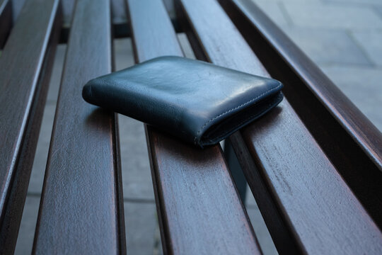 The lost wallet on the street, forgotten black leather object