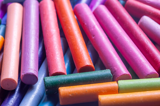 Pastels wax crayons, in various bright colours, background backdrop. Art and craft supplies concept