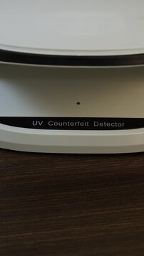 Examination of nepalese rupee (NPR) cash money with UV counterfeit detector. Concept of authenticity check, fight against counterfeiting of banknotes, anti fraud measures in Nepal. Close up view.