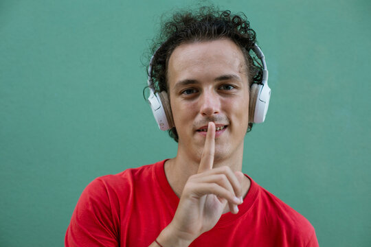 Man with finger on lips. Young man touching lips asking for silence.