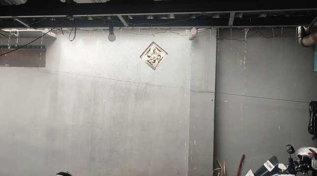 Rain falling from residential roof on rainy day