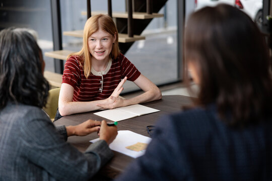 Young woman in meeting with two other people.