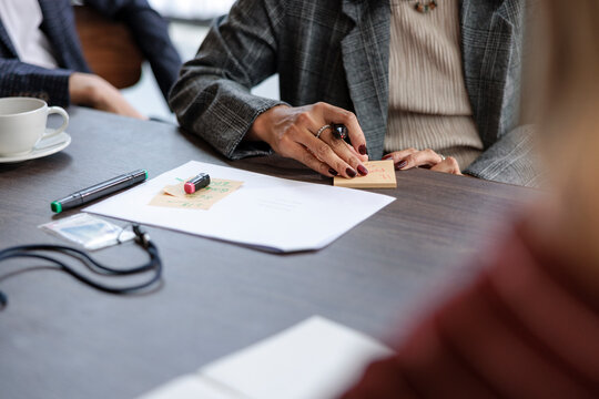 Woman writing on a sticky note during a meeting
