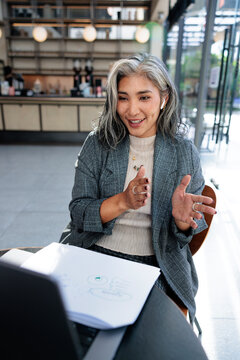 Professional woman leads a video call from a cafe workspace
