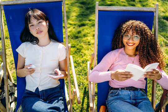 Two women relax sitting outdoors