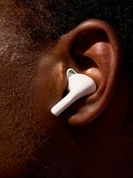 Close-up of Ear With Wireless Earbud in Use During Music Listening
