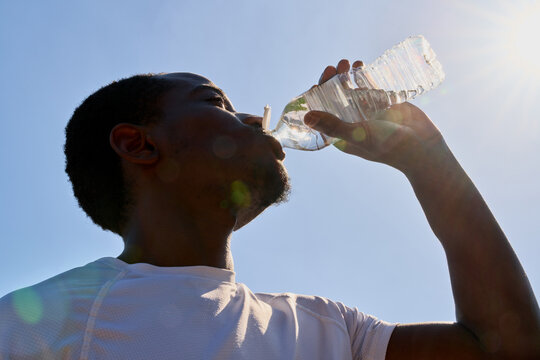 Person Drinks Water on a Sunny Day Outdoors