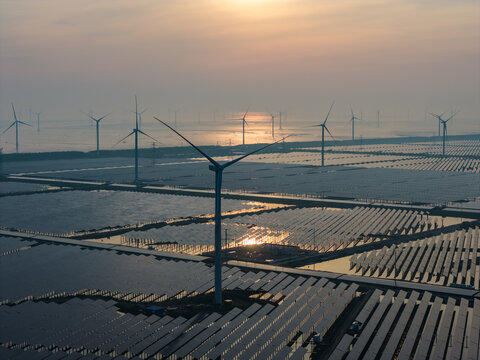  floating solar farm and wind turbines at sunset over water