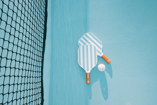 Pickleball Paddle and Ball Beside Net