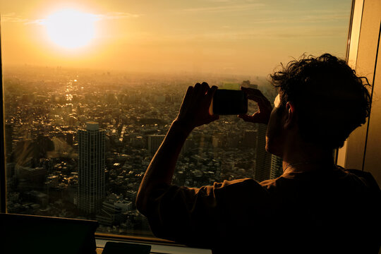 Man Photographing Tokyo Sunset from Above