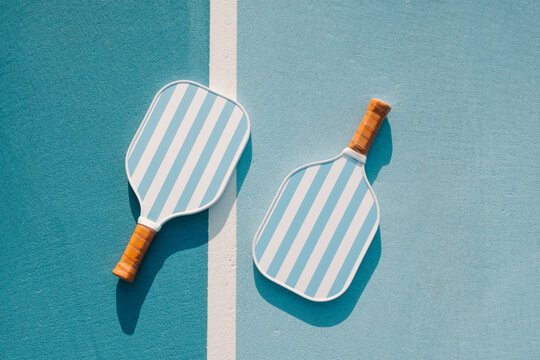 Two Pickleball Paddles on Blue Court